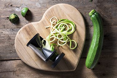 Heart-shaped cutting board with zucchini spiralizer