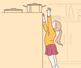little girl reaching for a pot on the stove
