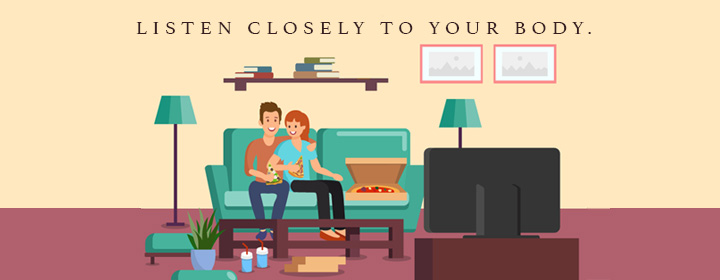 couple eating pizza in front of the TV