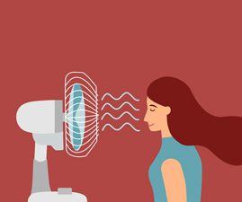 woman standing in front of a blowing fan