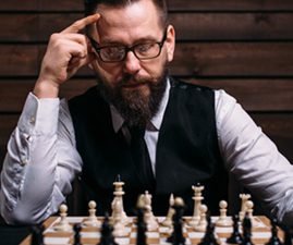 Man plays chess and seeks and advantage in the game.