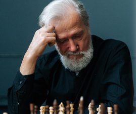 Man making a forced decision, looking down at a chessboard.