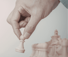 A man moves a pawn over a chess board.