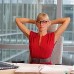 Woman with glasses doing yoga at desk