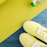 Yellow yoga mat and tennis shoes