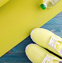 Yellow yoga mat and tennis shoes