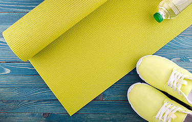 Yellow yoga mat and tennis shoes
