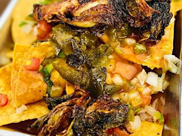 Grilled Brussels sprouts on top of barbeque nachos helps boost the nutrition