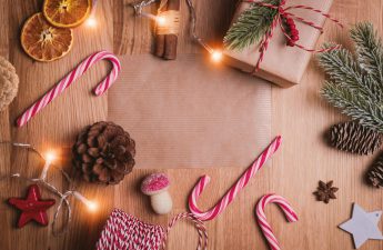 Healthy holiday and fun items are scattered across the floor, including string lights, pine cones, candy canes, wrapped gifts and more.